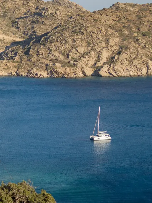 Catamaran anchored in crystal‑clear turquoise waters, a peaceful scene from La Dolce Vita in Greece.