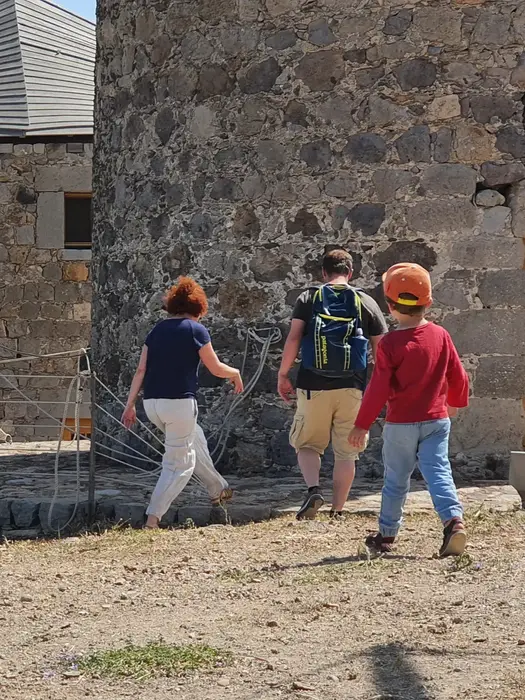 Family with young boy wearing red blouse and blue jeans while exploring ashore, Family Holiday in Greece.