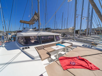 Bali 4.1 forward deck with spacious cushioned lounging area and table, perfect for relaxing.
