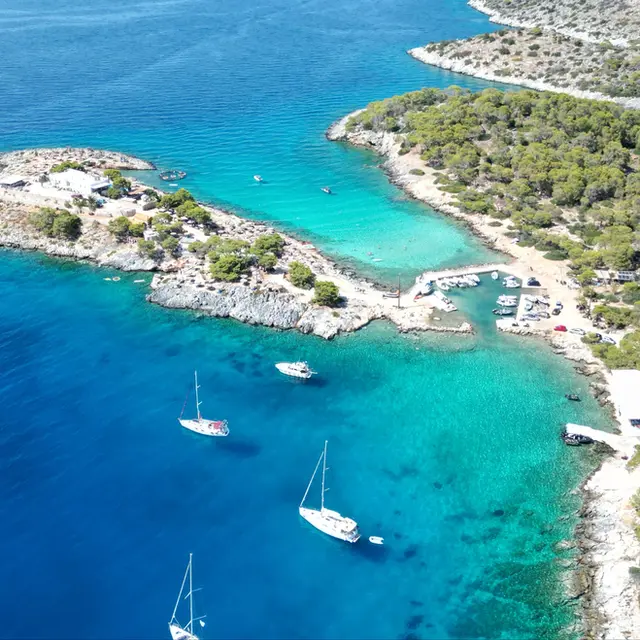 Aerial view of Aponisos anchorage, Agistri, wild coastline with a small taverna, med mooring practice spot on Docking Drills sailing course.