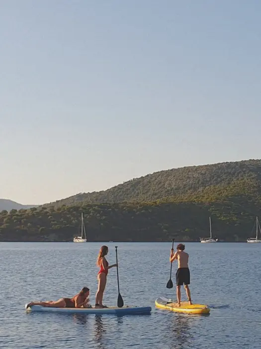 Mother and daughter on one SUP, boy on another, exploring the coastline, Family Holiday on the water.