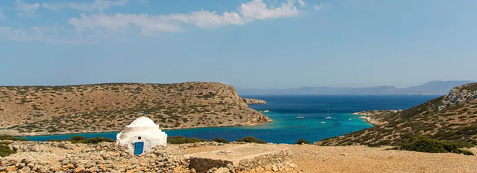 Small church in foreground, three boats anchored in turquoise water, distant island, dry Cycladic landscape, Epic Voyage sailing in Greece.