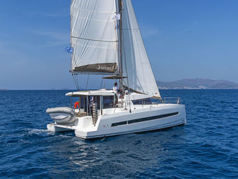 Bali 4.1 seen from astern under full sails, aerial view, white wake trailing.