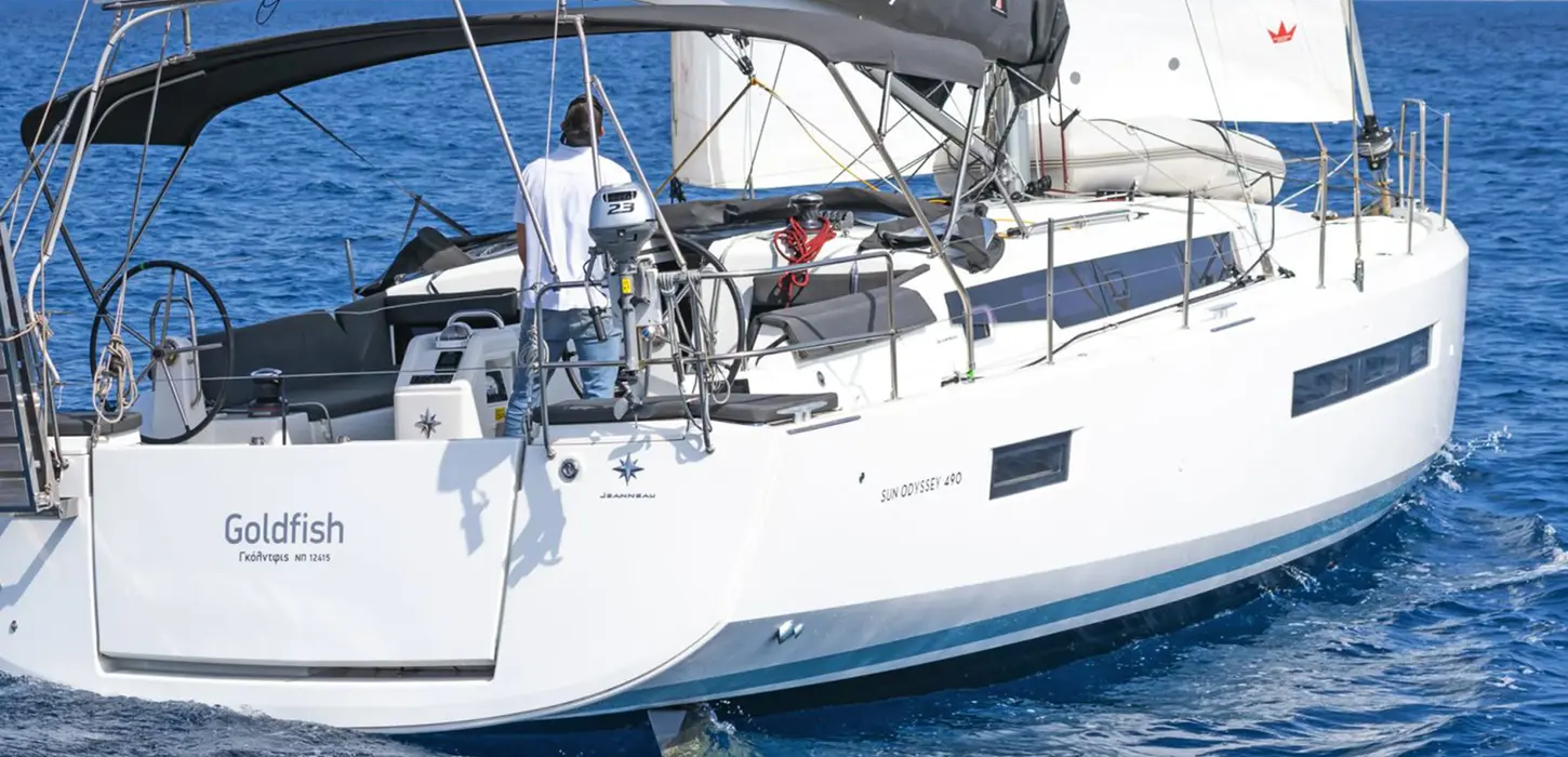 Jeanneau 490 viewed from astern under full sails, blue sea, Heavy Weather course vessel.