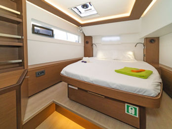 Lagoon 46 double cabin with comfortable berth, ample storage, and soft lighting.