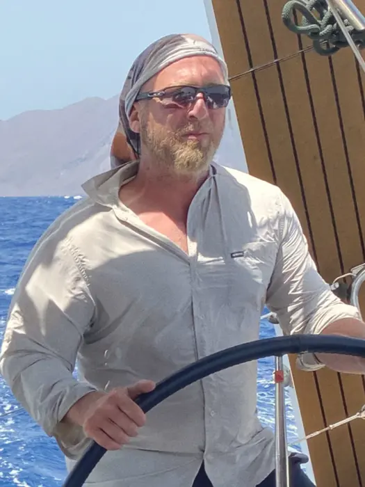 Focused crew member at helm, practicing docking technique, Docking Drills skill building.