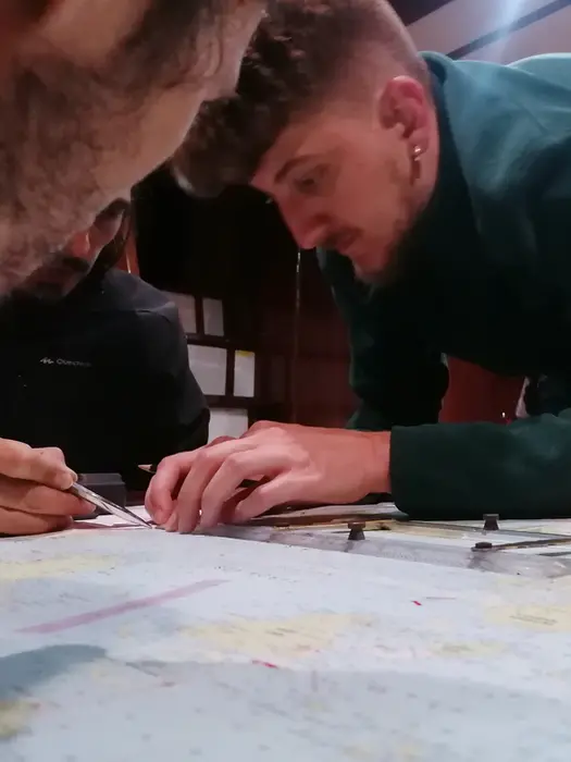 Navigation lesson with paper charts in saloon, Salty Fundamentals theory session.