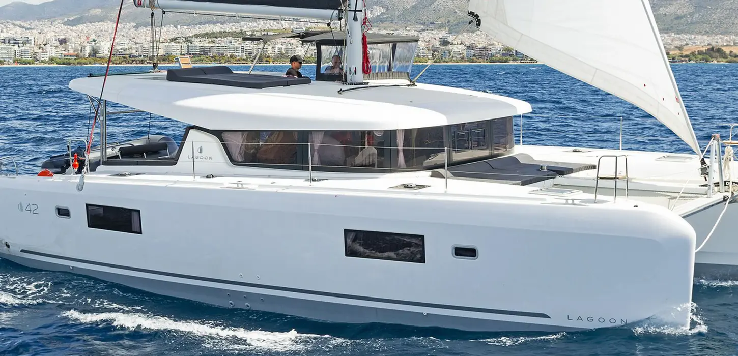 Lagoon 42 sailing on starboard tack with full sails, blue Aegean water, Catamaran Confidence training in Greece.