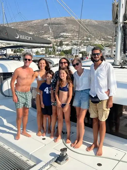 Smiling family posing with crew at trip’s end, joyful Family Holiday celebration.