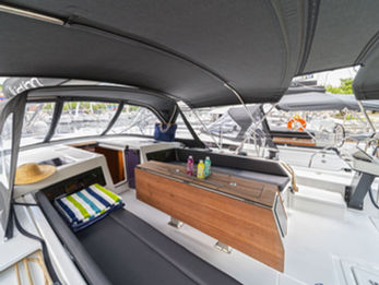 Dufour 470 cockpit with seating, folding table, and starboard helm station, inviting and well‑laid out.
