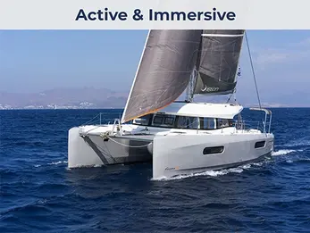 Aerial side view of an Excess 12 performance catamaran sailing with purpose, minimal wake, clear water.