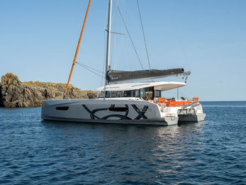 Excess 14 at anchor seen from astern, aerial view, spacious cockpit and swim platform.