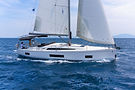 Aerial side view of a Beneteau Oceanis 46.1 monohull sailing smoothly, balanced and fast.