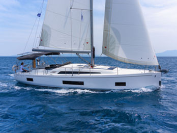 Beneteau Oceanis 46.1 sailing toward the camera under full sails, aerial forward view, Aegean blue waters.