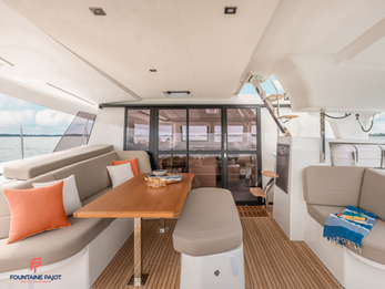 Fountaine Pajot FP41 exterior saloon with warm gray upholstery and generous seating area.