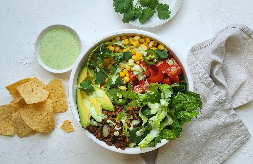 Serving platter with Honey Mustard Broccoli Crunch Salad. Hand of someone scooping the salad