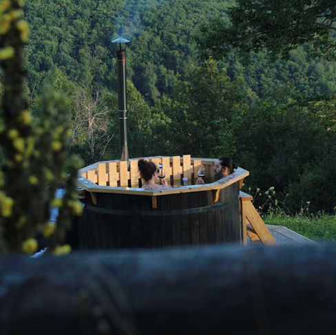 La nostra tinozza Hot tub con acqua riscaldata a legna per sorseggiare un buon bicchiere di vino al tramonto