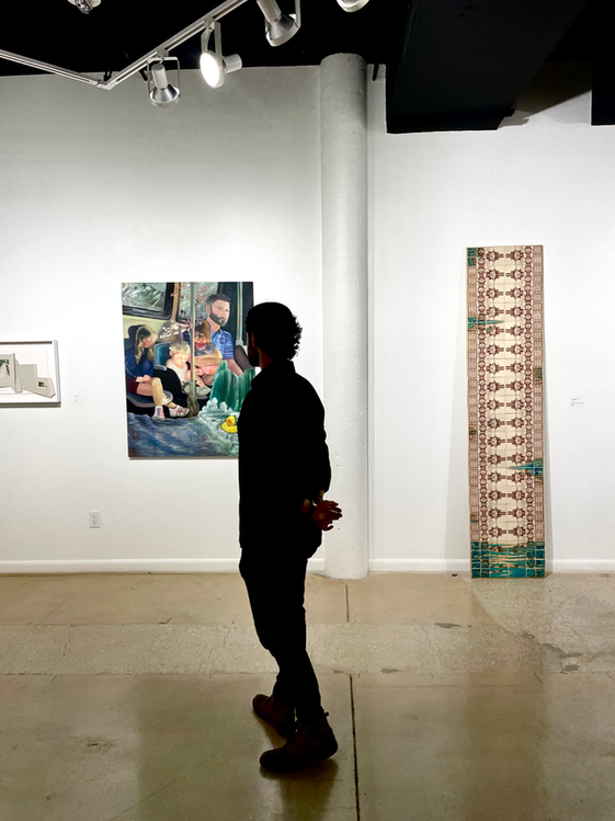 Matt J. Whitman looking at his painting "Cupid's Dilema" at an art show at Cornel Museum of Art.