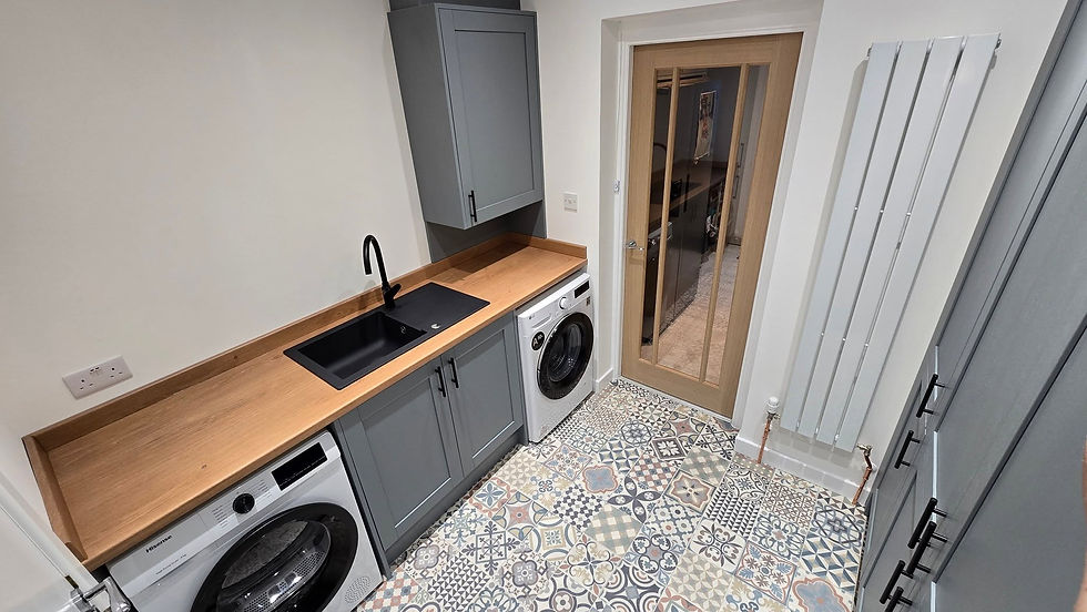 Modern utility room with grey cabinets wooden worktop black sink pattern floor tiles