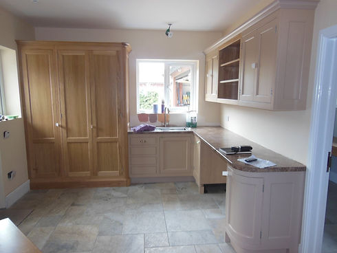 Neutral-toned kitchen during installation with light oak and beige cabinets