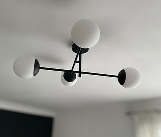 Modern ceiling light fixture with three spherical bulbs on a black metal frame