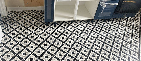 Black and white geometric patterned flooring in a kitchen being renovated