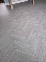 Modern grey herringbone style laminate flooring fitted in a residential room