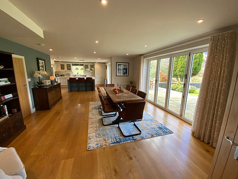 Staged dining area with large wooden dining table and sliding patio doors