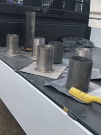 Several metal pipe vents or chimneys protruding through a flat roof surface