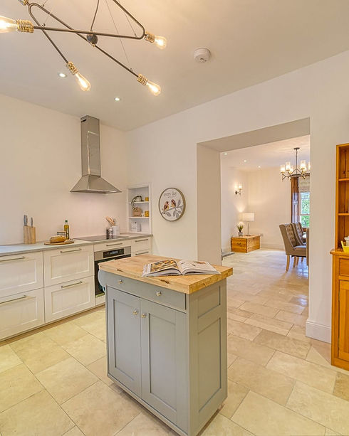 Spacious kitchen with grey island unit and open entrance into dining room   