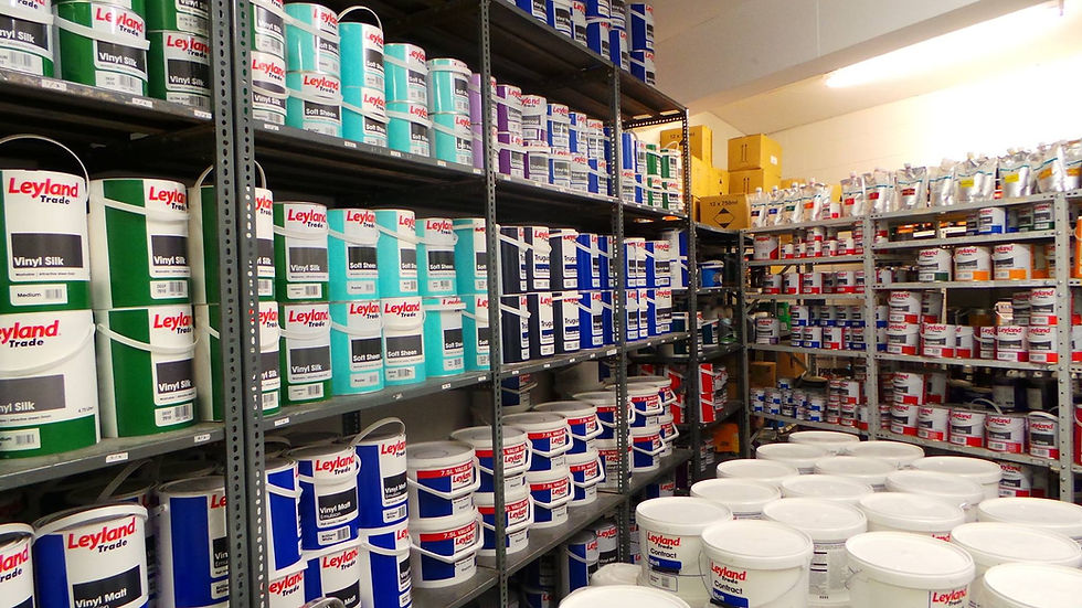 Shelves filled with colorful paint cans and buckets line a store's aisle
