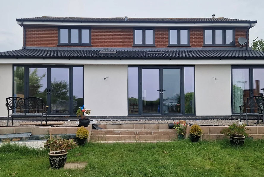 A modern two-story house with large glass doors, red brick and white walls