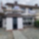 A two-story house undergoing renovations with scaffolding covering the front