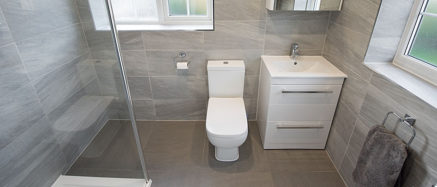 Modern bathroom featuring grey tiled walls and floor