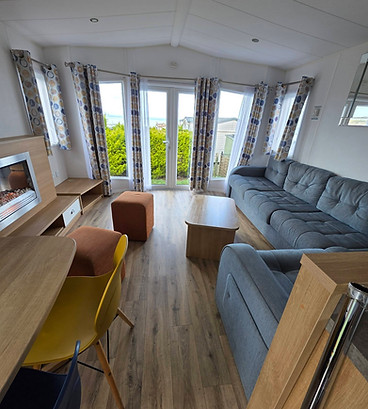 Cozy living room with a large grey couch, wooden floor