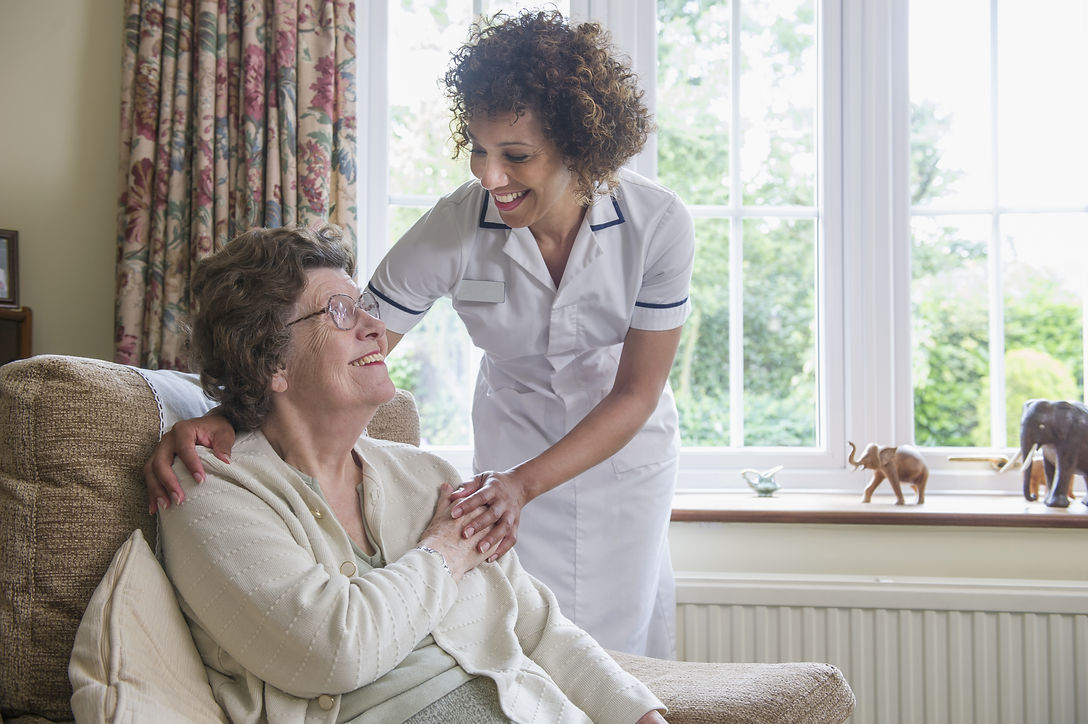 Older woman talking to caretaker in home