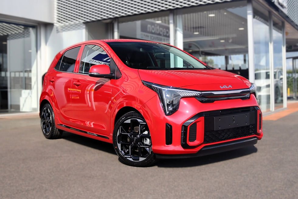 Bright red Kia hatchback parked outside a car dealership showroom forecourt