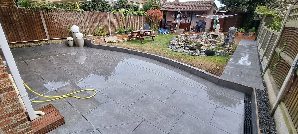 A large curved cobblestone driveway leading to a brick house with dark borders