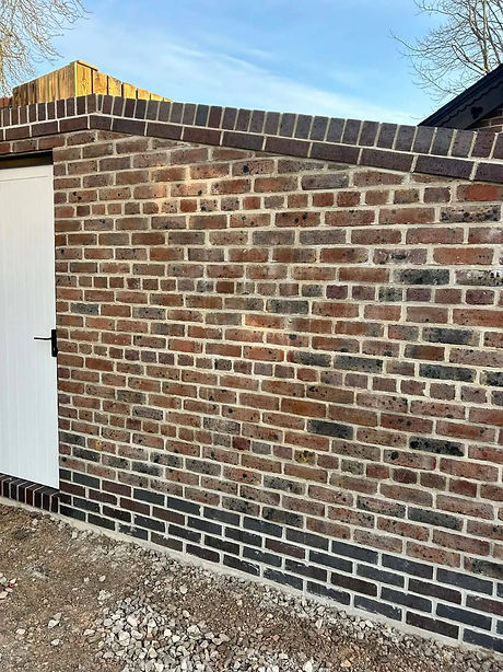 A brick wall with varied red and brown tones, featuring a white door on the left