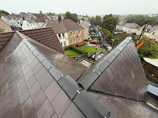 View over a residential area from a dark tiled roof with newly installed ridge caps