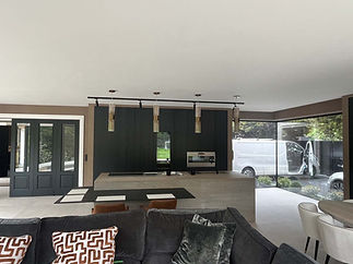 A modern living room featuring an open kitchen and dining area, showcasing contemporary furniture and decor