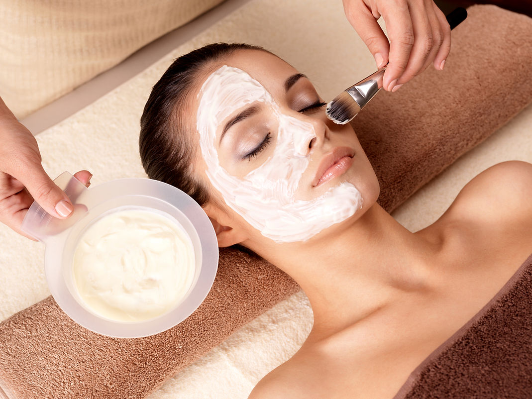 A woman with closed eyes receives a facial treatment