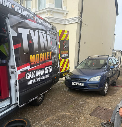 Mobile tire service van from "Tyres 4U" parked beside a blue car with a removed tire