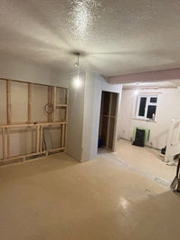 Empty room during building works featuring timber wall stud framing for partition walls