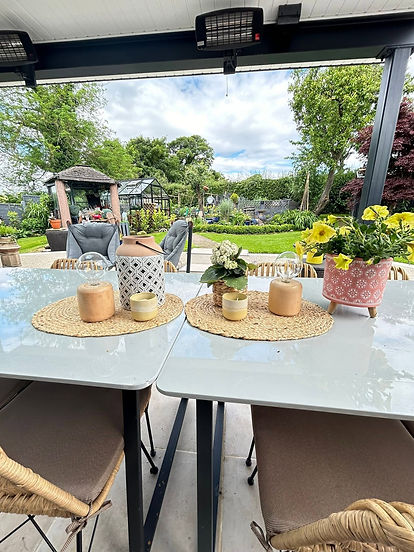 Outdoor garden patio dining table set with place mats candles and potted plants