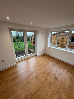 Empty room with wooden flooring white walls double glass doors