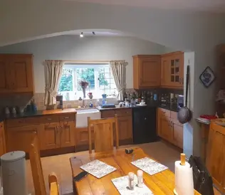 Warm, rustic kitchen with wooden cabinets and dining table