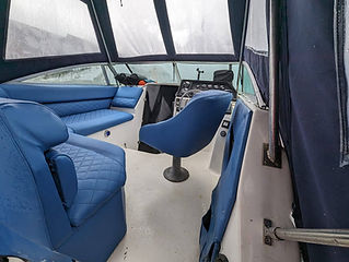 Blue quilted vinyl seating in a boat cockpit with a protective canopy
