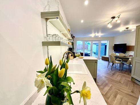 Bright open plan kitchen counter with yellow flowers and modern dining space