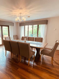 Elegantly staged formal dining room with large table setting and curtains